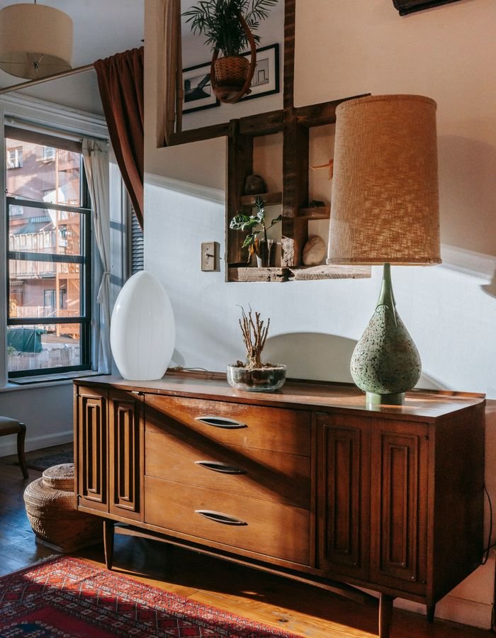 A walnut mid-century credenza with a ceramic table lamp